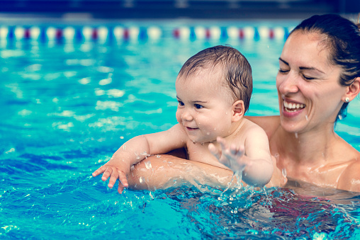 Cute baby boy enjoying with his mother in the pool.