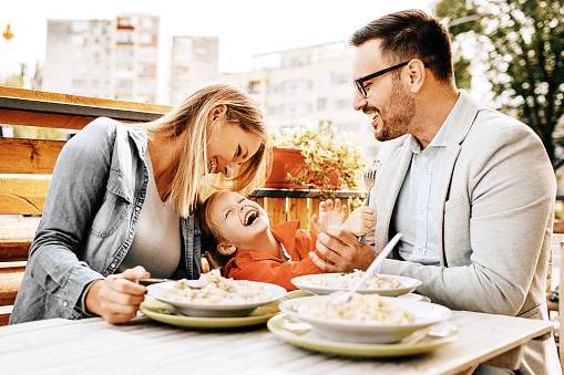 Happy family is enjoying pasta in restaurant. Happy family is enjoying pasta in restaurant.