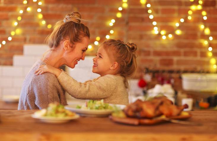 Blond woman and her little daughter hugging indoors