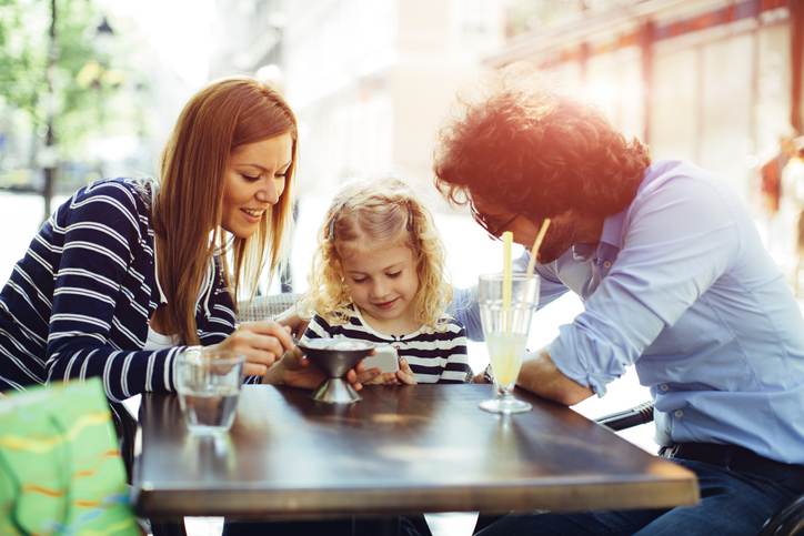 Father And Mother With Their Daughter in Cafe.